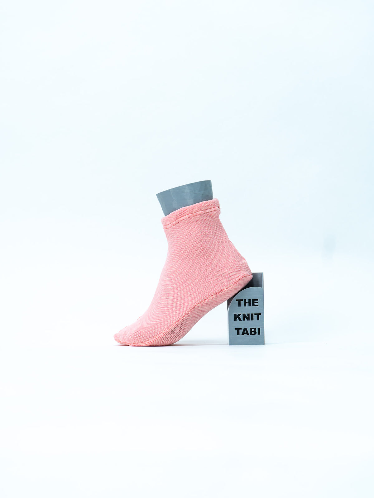 The Knit Tabi Sakura(桜・ピンク/シーズナルカラー)|片足を台に掛けて斜め横から|ISAMI